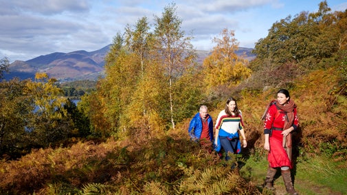 A group of three visitors walking at Borrowdale and Derwent Water, Cumbria